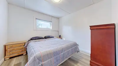 a bedroom with a bed and a dresser and a window at Main Beach River Retreat - Wasaga Beach 1 - Main Strip - 93 Mosley St in Wasaga Beach