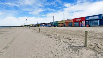 an empty beach with a building and a street at Main Beach River Retreat - Wasaga Beach 1 - Main Strip - 93 Mosley St in Wasaga Beach