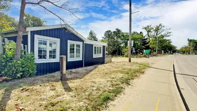 a blue building on the side of a street at Main Beach River Retreat - Wasaga Beach 1 - Main Strip - 93 Mosley St in Wasaga Beach