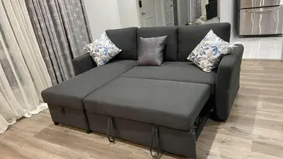 a gray couch and ottoman in a living room at Spectacular 3 BR 2 WR House - Close to Airport in Toronto