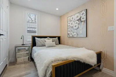 a bedroom with a bed with a white blanket at Luxe Lodges on Lake Erie in Port Dover
