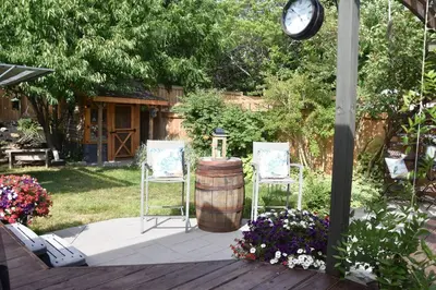 a patio with two chairs and a barrel and a clock at Cozy Suite with HOT TUB & Highspeed Internet in Grimsby