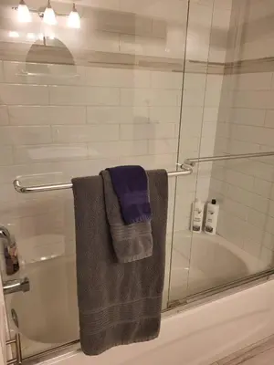 a bathroom with a glass shower with towels and a tub at Cozy Suite with HOT TUB & Highspeed Internet in Grimsby