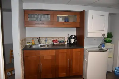 a small kitchen with wooden cabinets and a sink at Cozy Suite with HOT TUB & Highspeed Internet in Grimsby