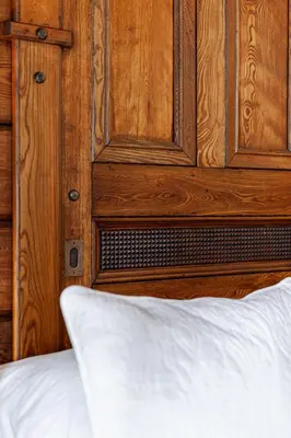 a close up of a bed with a wooden cabinet at Lake Suite with Sunroom by Henry House Stays in Stratford
