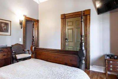 a bedroom with a bed and a mirror and a door at Lake Suite with Sunroom by Henry House Stays in Stratford