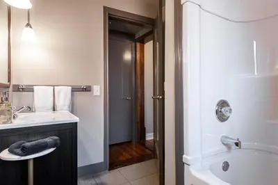 a bathroom with a sink and a toilet and a tub at Lake Suite with Sunroom by Henry House Stays in Stratford
