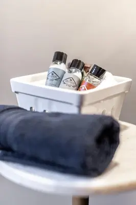 a container on a table with four bottles of alcohol at Lake Suite with Sunroom by Henry House Stays in Stratford