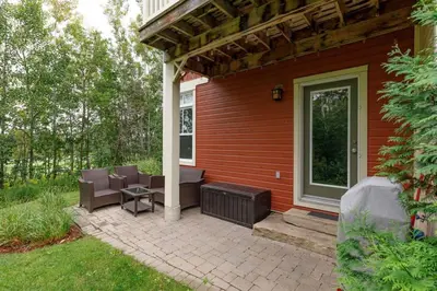 a patio with chairs and a grill on a house at Luxurious Rivergrass Blue Mountain Retreat in Blue Mountains
