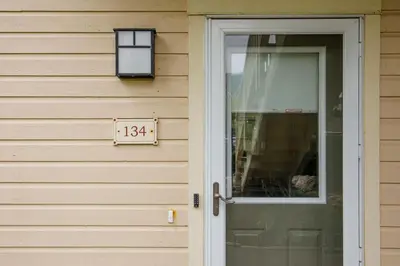 a door of a house with a sign next to it at Luxurious Rivergrass Blue Mountain Retreat in Blue Mountains