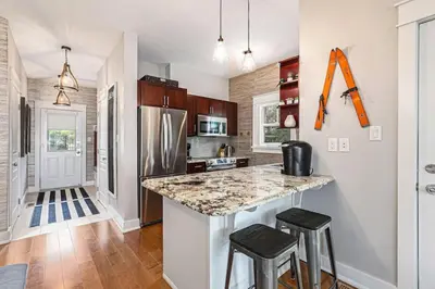a kitchen with a counter and two stools at Luxurious Rivergrass Blue Mountain Retreat in Blue Mountains