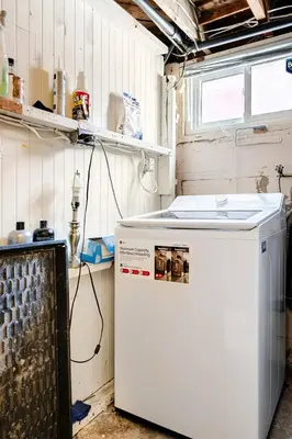a small white refrigerator in a room with a window at The Rustic Barn in Brampton