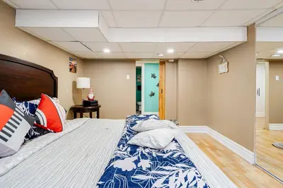 a bedroom with a large bed with a blue and white comforter at The Rustic Barn in Brampton