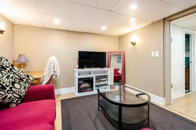 a living room with a red couch and a tv at The Rustic Barn in Brampton
