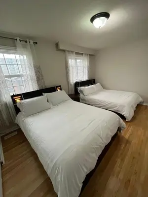two beds in a bedroom with white sheets at Full Privacy Apartment with Free Parkrings in Toronto