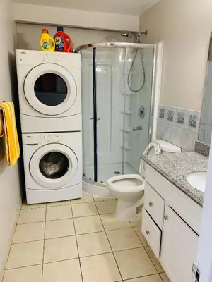 a bathroom with a washing machine and a toilet at Full Privacy Apartment with Free Parkrings in Toronto