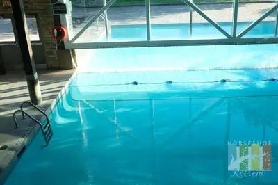 a swimming pool with blue water in a building at Horseshoe Retreat in Edgar
