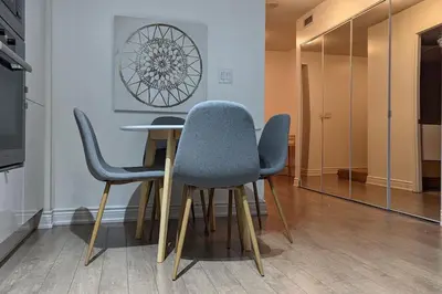 a dining room table with blue chairs and a mirror at Lovely 2 Bed Condo in Downtown Toronto in Toronto