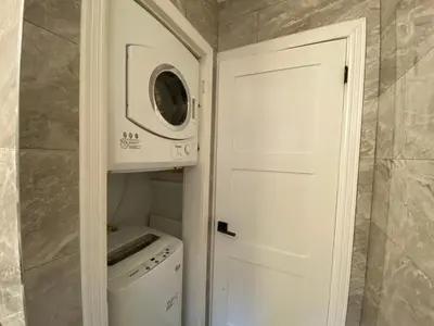 a laundry room with a microwave and a washer and dryer at Yonge and Finch Subway !L Spacious & Bright Private Bedroom with Shared Amenties in Toronto