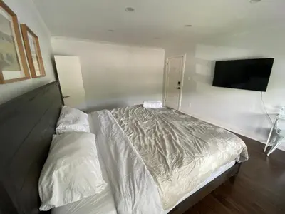 a bedroom with a bed and a flat screen tv at Yonge and Finch Subway !L Spacious & Bright Private Bedroom with Shared Amenties in Toronto