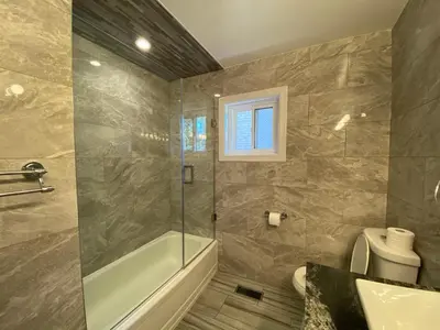 a bathroom with a shower and a tub and a sink at Yonge and Finch Subway !L Spacious & Bright Private Bedroom with Shared Amenties in Toronto