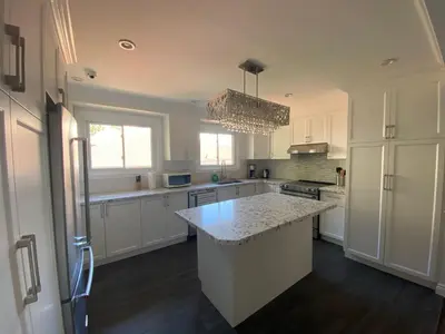 a kitchen with white cabinets and a large island at Yonge and Finch Subway !O Cozy & Modern Private Bdr with Private Half Bathroom in Toronto