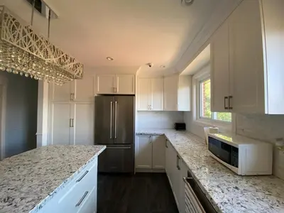 a kitchen with white cabinets and a stainless steel refrigerator at Yonge and Finch Subway !O Cozy & Modern Private Bdr with Private Half Bathroom in Toronto