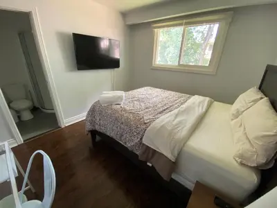 a bedroom with a bed and a flat screen tv at Yonge and Finch Subway !P Cozy & Quiet Private Bdr with Private Bathroom in Toronto