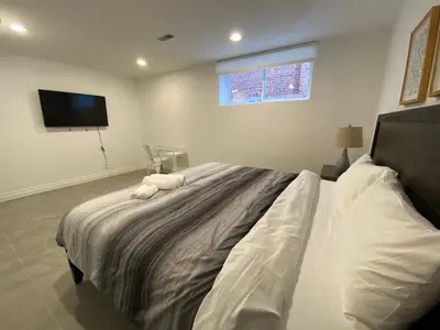 a bedroom with a large bed with a tv on the wall at Yorkmills and Bayview !B Spacious and Stylish Private Bdr with Shared Bathroom in Toronto
