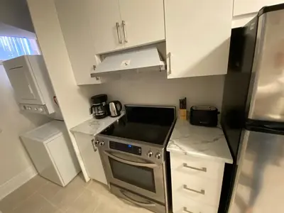 a small kitchen with a stove and a refrigerator at Yorkmills and Bayview !A Spacious and Modern Private Bdr with Shared Bathroom in Toronto