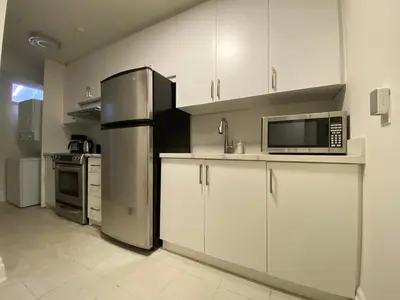 a kitchen with white cabinets and a stainless steel refrigerator at Yorkmills and Bayview !A Spacious and Modern Private Bdr with Shared Bathroom in Toronto