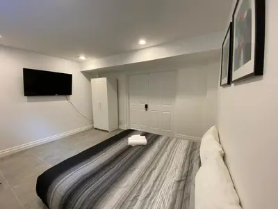 a living room with a couch and a flat screen tv at Yorkmills and Bayview !A Spacious and Modern Private Bdr with Shared Bathroom in Toronto