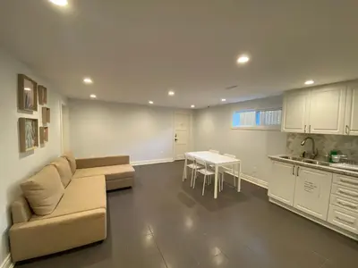 a living room with a couch and a table and a kitchen at Yonge and Finch Subway !R Spacious & Stylish Prvt Bdr with Shared Bathroom in Toronto