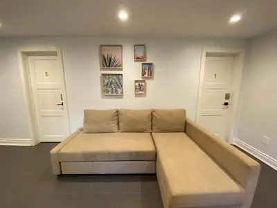 a couch in a living room with two doors at Yonge and Finch Subway !R Spacious & Stylish Prvt Bdr with Shared Bathroom in Toronto