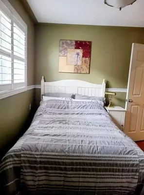 a bedroom with a large bed with a striped blanket at Top Floor of House in S Vaughan All to Yourself in Vaughan