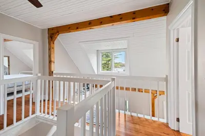 a white staircase in a home with a window at Marmora Retreat - Unique Waterfront Farmhouse in Marmora