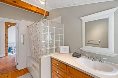 a bathroom with a sink and a tub and a mirror at Marmora Retreat - Unique Waterfront Farmhouse in Marmora