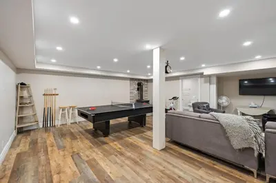 a living room with a couch and a pool table at Marmora Retreat - Unique Waterfront Farmhouse in Marmora