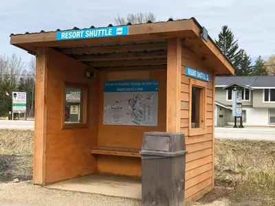 a wooden bus stop with a trash can next to it at Slope-side Studio Bliss Ski-in Ski-out, Renovated At Blue, Hot Tub, Fast Wi-Fi in Blue Mountains