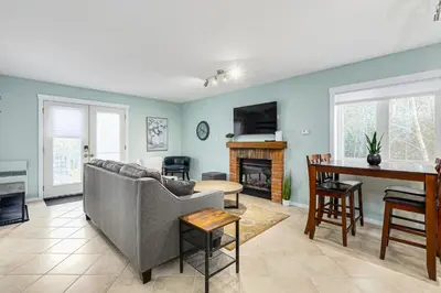 a living room with a couch and a table at The Alpine - Central Collingwood Condo in Collingwood