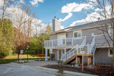 a house with a white deck and a staircase at The Alpine - Central Collingwood Condo in Collingwood
