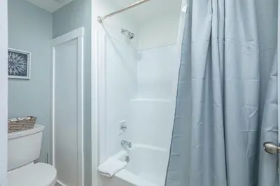 a bathroom with a shower curtain and a toilet at The Alpine - Central Collingwood Condo in Collingwood