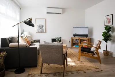 a living room with a couch and a table and a tv at The Darcie House - cozy, pet-friendly home in PEC in Picton