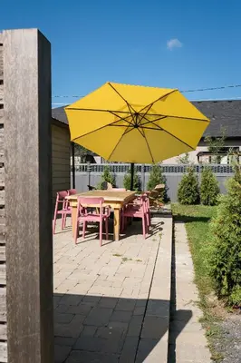 a yellow umbrella on a patio with a table and chairs at The Darcie House - cozy, pet-friendly home in PEC in Picton