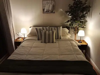 a bedroom with a large bed with pillows and two lamps at Fireside - Waterfront Resort Style Executive Cottage in Kawartha Lakes