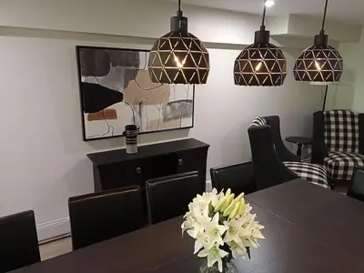 a dining room with a table and pendant lights at Fireside - Waterfront Resort Style Executive Cottage in Kawartha Lakes