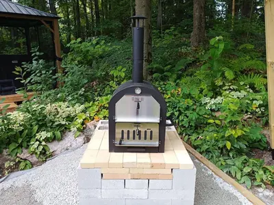 a stove sitting on a brick block in a garden at Fireside - Waterfront Resort Style Executive Cottage in Kawartha Lakes