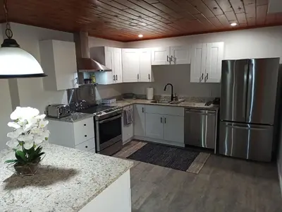 a kitchen with white cabinets and stainless steel appliances at Fireside - Waterfront Resort Style Executive Cottage in Kawartha Lakes