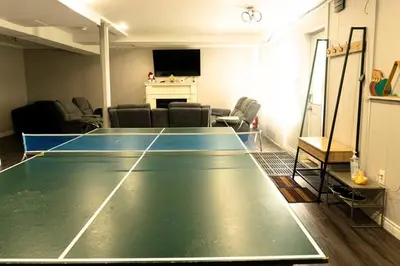 a living room with a ping pong table in it at Cozy Sunset Cottage Overlooking Rice Lake in Roseneath