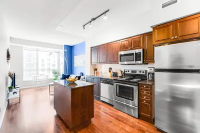 a kitchen with stainless steel appliances and wooden cabinets at AOC Suites - High-Rise Condo - City View in Toronto
